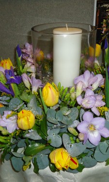 Hurricane vase with candle surrounded by lilac & yellow wreath ring