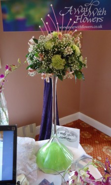 Green carnations and pink alstromeria arranged on upturned martini vase