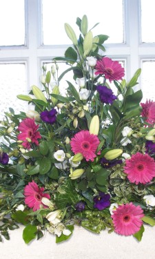 Window arrangement with pink gerbera, ivory lilies, lizianthus & purple lizianthus
