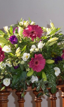 Small low arrangement with pink gerbera, ivory lilies and lizianthus and purple lizianthus