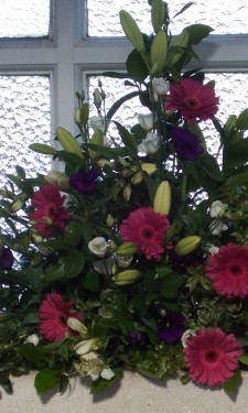 Window arrangement with pink gerbera, ivory lilies, lizianthus & purple lizianthus