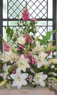 Window arrangement with ivory lilies, and lizianthus, pink bouvardia and anthirrhinums and Solomon's seal