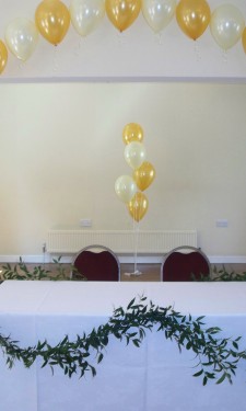 Gold and Ivory balloon arch with soft ruscus table garland