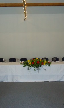 Top table setting with central arrangement and candelabra at Crug Glas