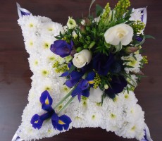 White based pillow wreath with blue iris ivory rose and freesia