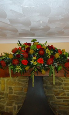 Mixed autumn colours provided by proteas, roses, chrysanthemum and alstromeria and trailing amaranthus