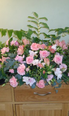 Sideboard arrangement of pink roses, carnations, freesia, lizianthus and Solomon's seal
