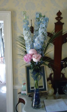 Pink peonies, blue delphiniums and phoenix palm leaves at reception area