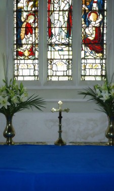 Altar arrangement of ivory lilies, phoenix palm leaves and steel grass