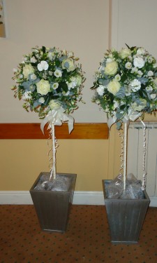 Ivory topiary trees trimmed with ribbon