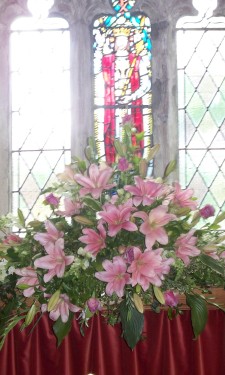 Altar arrangement of pink lily, roses and bridal gladiolus
