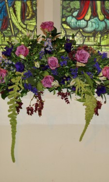 Window arrangement with pink roses, hydrangea and purple lizianthus and trailing amaranthus
