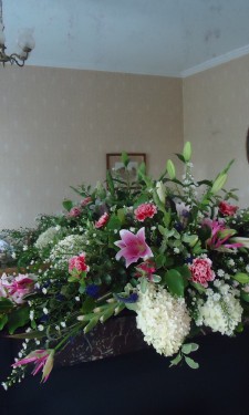 Mantelpiece arrangement with pink lily, carnation and gladiolus and ivory hydrangea and September flower
