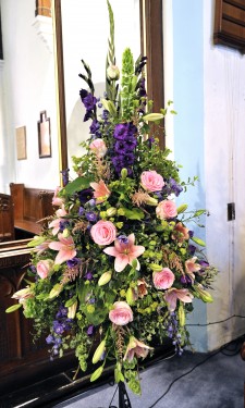 Large pedestal arrangement with pink lilies, esperance roses, purple lizianthus, astilbe & delphinium