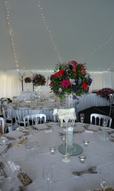 Round arrangements of gerbera, freesia & lizianthus on top of conical vases