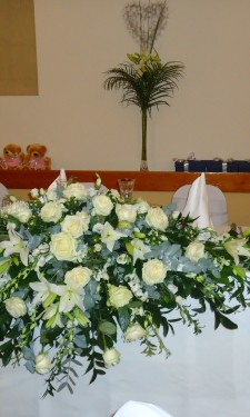 Ivory Top table arrangement with roses, lilies, singapore orchids, lizianthus, and eucalyptus.