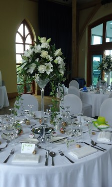 Oriental lilies, roses, carnations, freesia and trailing ivy in martini vases